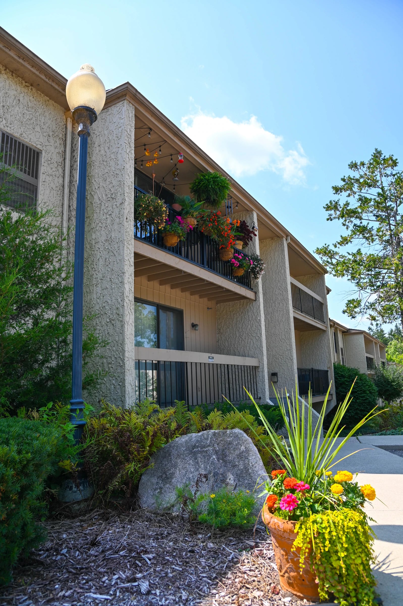 Flowers and planting beds beside apartment balconies